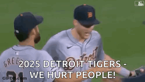 A Couple Of Baseball Players Are Hugging Each Other On A Baseball Field . GIF
