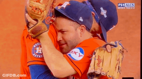 A Couple Of Baseball Players Hugging Each Other With The Fs1 Alcs Series Tied 2-2 GIF