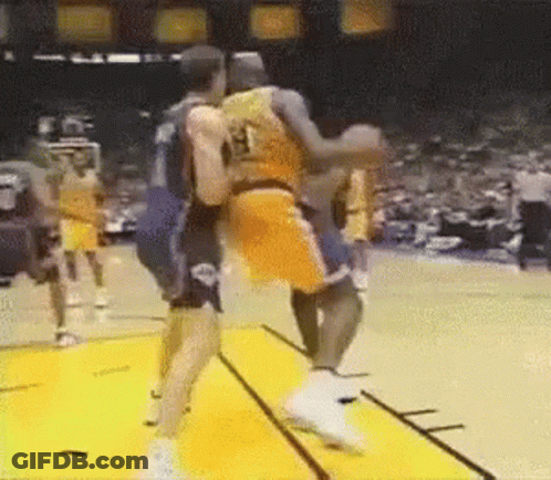 A Couple Of Basketball Players Are Fighting On A Court . GIF