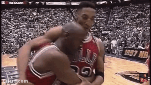 A Couple Of Basketball Players Are Hugging Each Other On A Court . GIF
