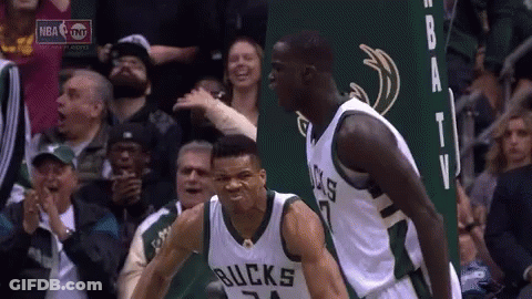 A Couple Of Basketball Players Are Standing Next To Each Other In Front Of A Crowd Of People . GIF