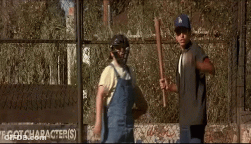 A Couple Of Boys Are Standing Next To Each Other In Front Of A Fence . GIF