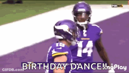 A Couple Of Football Players Are Standing On A Purple Field And One Of Them Is Wearing A Number 14 Jersey . GIF