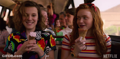 A Couple Of Girls Are Eating Ice Cream Cones On A Bus . GIF