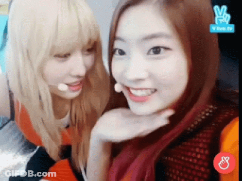 A Couple Of Girls Are Sitting Next To Each Other And Smiling For The Camera . GIF