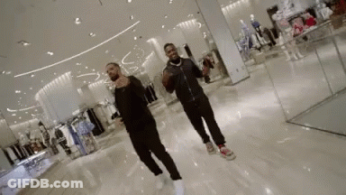A Couple Of Men Are Dancing In A Store . GIF