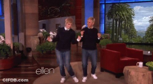 A Couple Of Men Are Dancing In Front Of A Sign That Says Ellen GIF