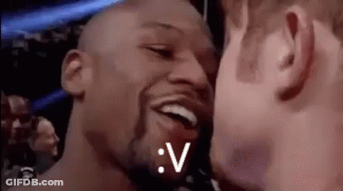 A Couple Of Men Are Kissing Each Other In A Boxing Ring . GIF