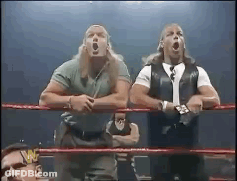 A Couple Of Men Are Standing In A Wrestling Ring . GIF