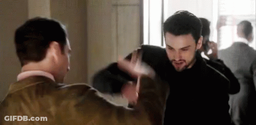 A Couple Of Men Are Standing Next To Each Other In A Room . GIF