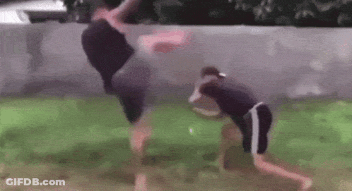 A Couple Of Men Are Standing Next To Each Other In A Yard . GIF