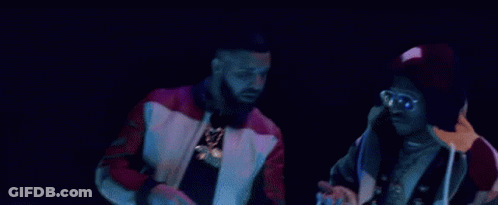 A Couple Of Men Are Standing Next To Each Other On A Stage . GIF