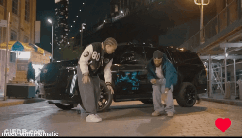 A Couple Of Men Standing Next To A Car With The Number 80 On It GIF