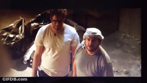 A Couple Of Men Standing Next To Each Other In A Room GIF