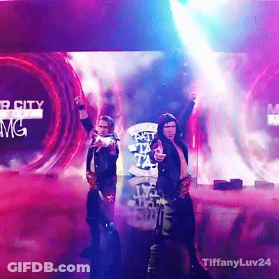 A Couple Of Men Standing On A Stage In Front Of A Screen That Says Mgm GIF