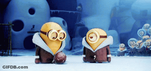A Couple Of Minions Standing Next To Each Other With One Wearing Goggles And A Football GIF