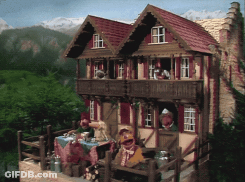 A Couple Of Muppets Are Sitting Outside Of A House GIF