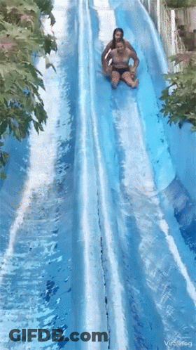 A Couple Of People Are Going Down A Water Slide At A Water Park .. GIF