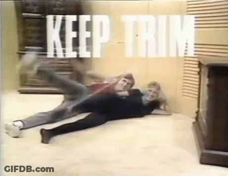 A Couple Of People Are Laying On The Floor In A Room With The Words `` Keep Trim '' Written On The Wall . GIF