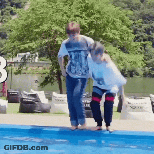 A Couple Of People Are Standing Next To Each Other In A Pool . GIF