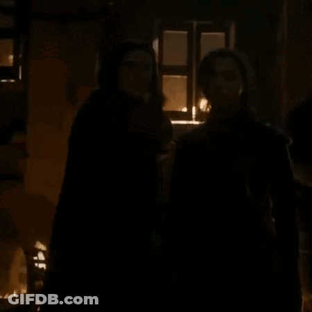 A Couple Of People Standing In A Dark Room With The Words What Do We Say To The God Of Death GIF