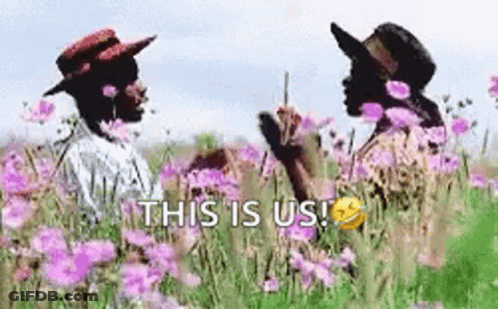 A Couple Of People Standing In A Field Of Purple Flowers . GIF