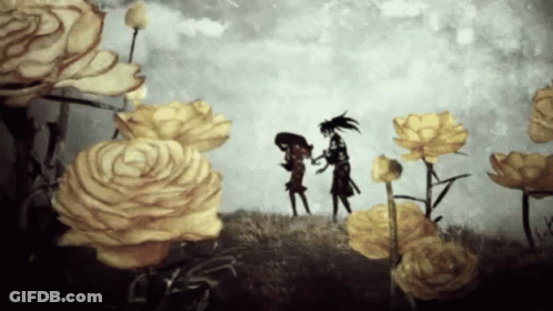 A Couple Of People Standing In A Field Of Yellow Flowers GIF