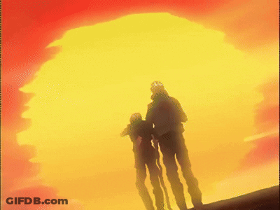 A Couple Of People Standing In Front Of A Large Yellow And Red Sun GIF