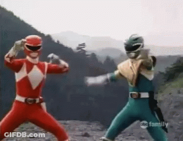 A Couple Of Power Rangers Are Standing Next To Each Other On A Rocky Hillside . GIF