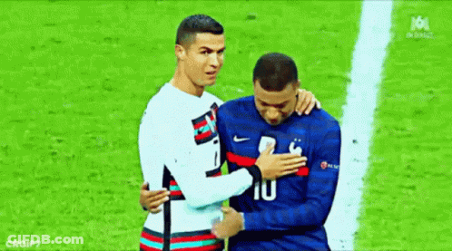 A Couple Of Soccer Players Are Hugging Each Other On A Field . GIF
