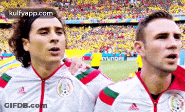 A Couple Of Soccer Players Are Standing Next To Each Other On A Field . GIF