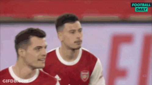 A Couple Of Soccer Players Are Standing Next To Each Other On A Field With A Football Daily Logo In The Background . GIF