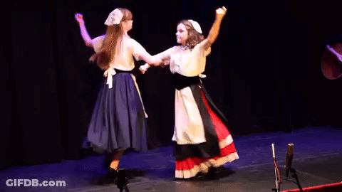 A Couple Of Women Are Dancing On A Stage . GIF