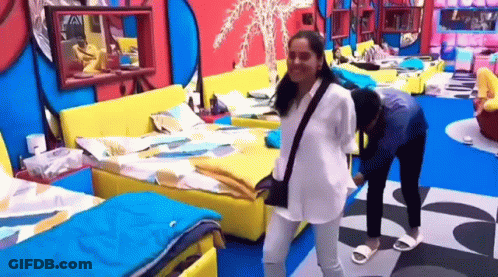 A Couple Of Women Are Standing Next To Each Other In A Bedroom . GIF
