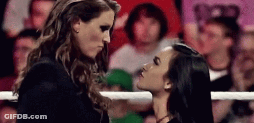 A Couple Of Women Are Standing Next To Each Other In A Ring And Kissing . GIF