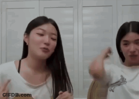 A Couple Of Women Are Standing Next To Each Other In A Room . GIF