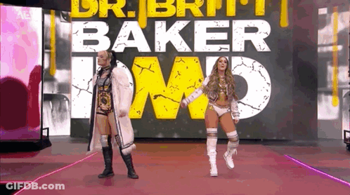 A Couple Of Women Standing Next To Each Other On A Red Carpet In Front Of A Large Sign . GIF