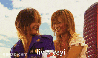 A Couple Of Women Standing Next To Each Other With The Words Liv & Yayi Written On The Bottom GIF