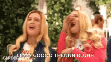 A Couple Of Women Standing Next To Each Other With Their Mouths Open And Laughing . GIF