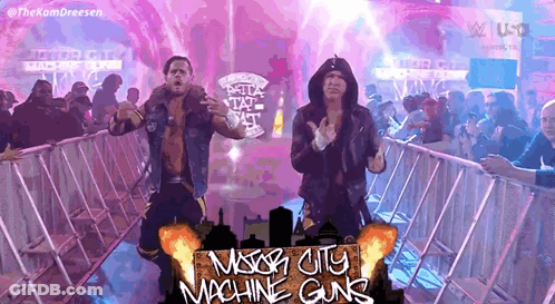 A Couple Of Wrestlers Are Standing In Front Of A Crowd And A Sign That Says Mason City Machine Guns GIF
