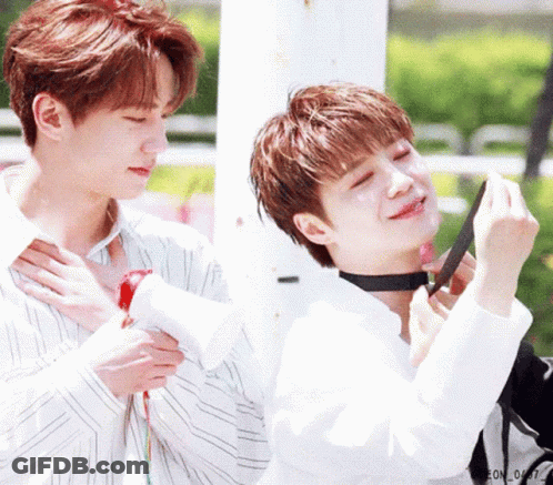 A Couple Of Young Men Are Standing Next To Each Other And One Of Them Is Wearing A Choker Around His Neck . GIF