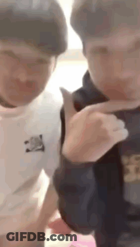 A Couple Of Young Men Are Standing Next To Each Other And Talking . GIF