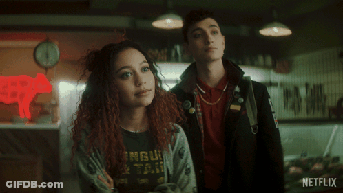 A Couple Standing In Front Of A Netflix Sign GIF