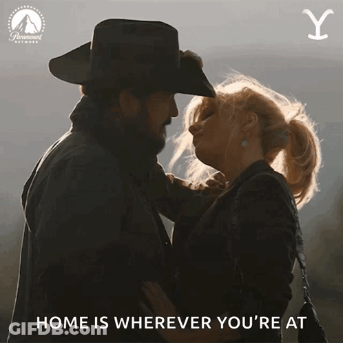 A Cowboy And A Woman Are Kissing With The Words " Home Is Wherever You 'Re At " GIF
