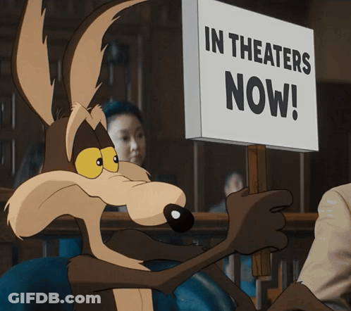 A Coyote Is Holding A Sign That Says In Theaters Now GIF
