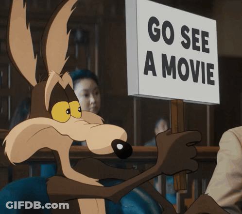 A Coyote Is Holding Up A Sign That Says Go See A Movie GIF