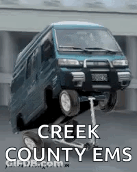 A Creek County Ems Poster With A Blue Van On A Scooter GIF