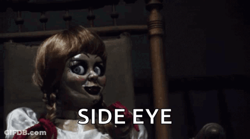 A Creepy Doll Is Sitting In A Chair With The Words `` Side Eye '' Written Below Her . GIF