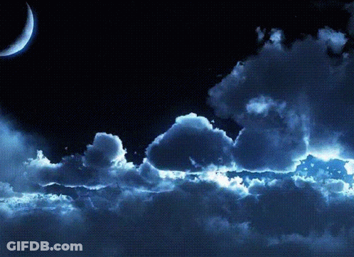 A Crescent Moon Is Visible In The Night Sky Above The Clouds GIF