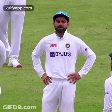 A Cricket Player Is Standing On A Field With His Hands On His Hips And Looking At The Camera . GIF